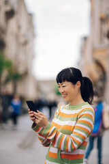 Fototapeta premium Joyful japanese girl enjoying a spring day while having an online video call.