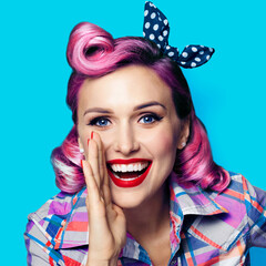Beautiful happy excited woman holding hand near open mouth. Girl dressed in pin up. Blond model at...