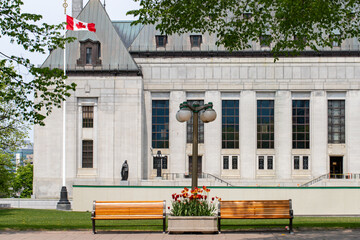 Supreme Court of Canada building with flag in spring.