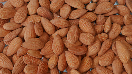Close-up of organic, peeled almonds falling on table.. Nutty, crunchy snack packed with protein and vitamins. Concept of healthy eating and nutrition.