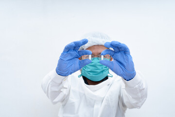 The medical doctor holds a capsule pill in hand on the white background