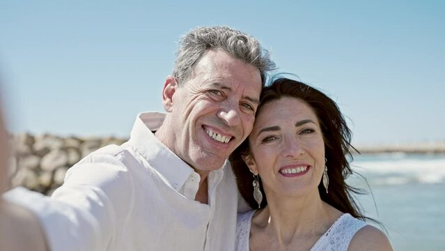 Senior man and woman couple smiling confident make selfie by camera at seaside