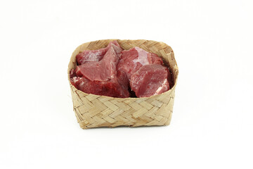 Pieces of fresh sacrificial meat in a traditional Indonesian bamboo container, celebrating Eid al-Adha,isolate on white background
