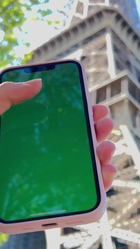 A woman's hand with vitiligo holds smartphone with green screen. Back view shot. Chroma key, close up woman hand holding phone with vertical green screen. High quality 4k footage