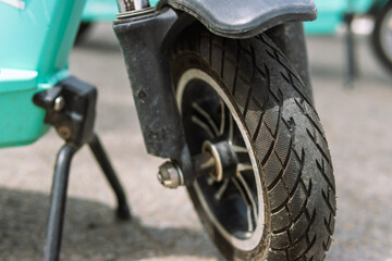 front wheel from an electric scooter close-up, the scooter stands on a leg on the street