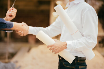 Close-up of a handshake of 2 Asian male engineers as a mechanic and a supervisor in a construction...