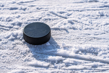 hockey puck lies on the snow close-up