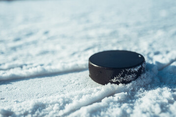 hockey puck lies on the snow close-up