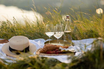Beautiful summer picnic in the park with tasty fresh berries, croissants and wine. Pleasure time at...