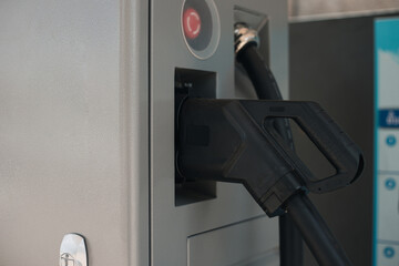 Image of Electric vehicle charging station for charge EV battery. Plug for vehicle with electric engine. EV charger service. Clean energy. Charging point at car parking lot. copy space for text.