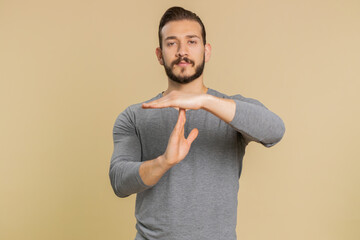 Tired serious upset young lebanese man showing time out gesture, limit or stop sign, no pressure, I...