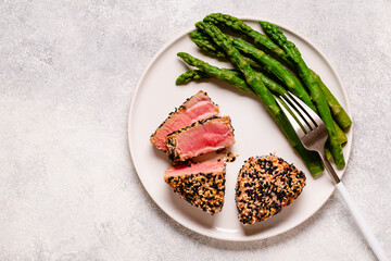 Tuna steak fried in sesame seeds served with asparagus.