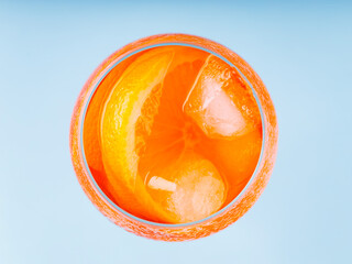 Aperol Spritz cocktail in glass on a blue background. Cocktail Aperol Spritz with orange slice and ice cubes. Top view