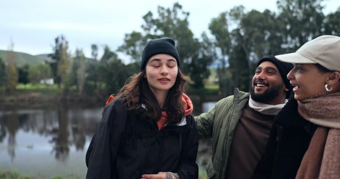Friends, hiking and people at a lake in nature while pointing at view or destination for journey. Women and a man walking together as a group for a hike, trekking adventure or travel in countryside