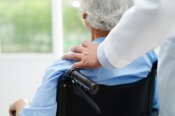 Doctor help Asian elderly woman disability patient sitting on wheelchair in hospital, medical concept.