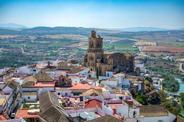 View from above of the old town of Arcos de la Frontera, Cadiz, Andalusia, Spain, with the imposing church of San Pedro in the middle and the landscape behind,  © AntonioLopez