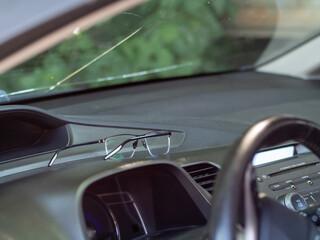 glasses lie on the dashboard of the car