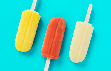 Close up of popsicles on the light blue background. 青色背景上の棒つきアイスキャンディのクローズアップ