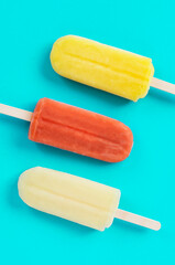 Close up of popsicles on the light blue background. 青色背景上の棒つきアイスキャンディのクローズアップ