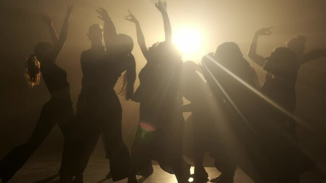 Silhouette of modern ballet dancers. Artists in the dance show how the trees are eared in the wind.