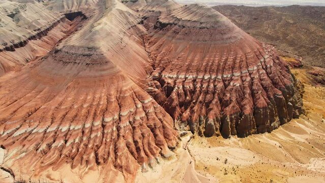 Beautiful Aktau mountains in Altyn-Emel National Park on a bright summer day. Red mountains formed by sedimentary rocks. Aerialview of sandy rocks in the wild.