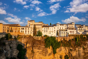 Fototapeta na wymiar View of the old part of Ronda, Malaga, Spain, with the houses on the edge of a high-rise rock in evening light