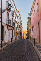 Fototapeta na wymiar Cobbled and sloping street in the Chiado neighborhood in Lisbon, Portugal.