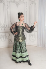 Beautiful young smiling woman wearing green medieval vintage Victorian Style dress stand