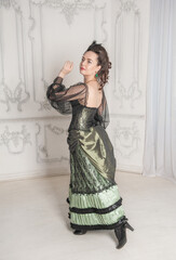 Beautiful young smiling woman wearing green medieval vintage Victorian Style dress turn
