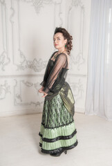 Beautiful young smiling woman wearing green medieval vintage Victorian Style dress stand