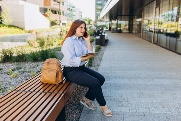 Fototapeta na wymiar Upset young woman talking over phone disappointed hear bad news, sad pensive girl speaking having unpleasant smartphone conversation and siting on the bench at city street. Negative emotions