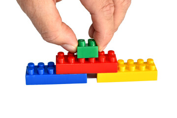 Fototapeta premium The man's hand folds the details of the children's designer.