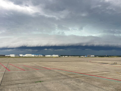 Shot of an arcus storm cloud gust front moving over the buildings of an airport