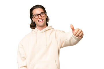 Naklejka premium Young caucasian man isolated on green chroma background giving a thumbs up gesture