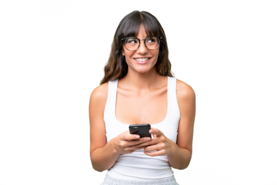 Young caucasian woman over isolated background using mobile phone and looking up