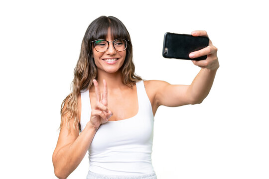 Young caucasian woman over isolated background making a selfie with mobile phone