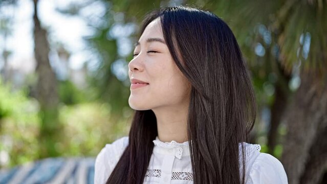 Young chinese woman smiling confident looking to the side at park