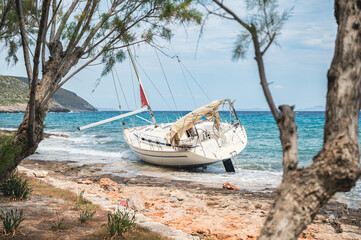 Wreck of a recreational sailing yacht beached on the shore