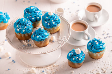Tasty and beautiful cupcakes with blue whipped cream.