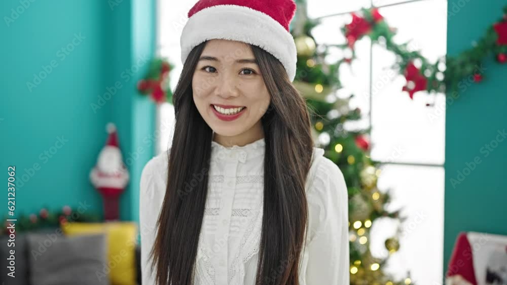 Poster Young chinese woman celebrating christmas smiling at home