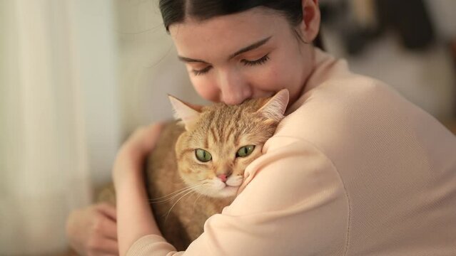 Happy Asian woman enjoying playing with her cute pet at home.