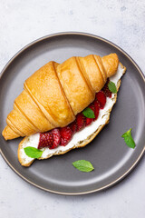 Croissant with strawberries, white cheese and mint. Breakfast. Vegetarian food.