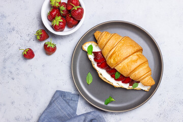 Croissant with strawberries, white cheese and mint. Breakfast. Vegetarian food.