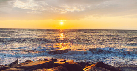 Seascape, sea landscape with waves and rocky coast at sunny sunset in the evening