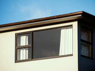 Window with three-panel awning frame under flat roof