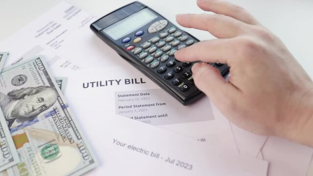 Utility bill, Heat and water utility bill for a house, hand on the calculator counts the cost of gas and electricity