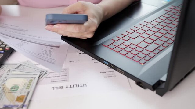 woman pays utility bills online on smartphone, Energy bill showing electricity and gas, Heat and water utility bill for a house