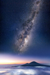 Plakat Mount Batur at sunrise with the milky way high above the volcano during sunrise
