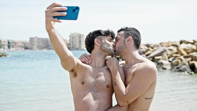Two men tourist couple smiling confident make selfie by smartphone at beach