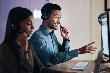 Man, call center and headphones at night in customer service, support or telemarketing at the...